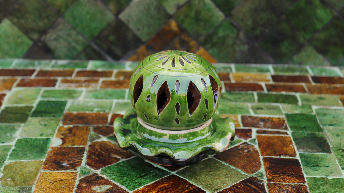 a green ceramic object on a tile surface